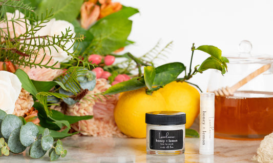 Glass jar of honey + lemon luxe lip scrub and a nourishing lip balm.